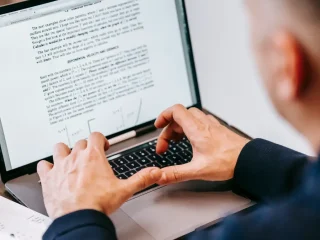 person editing a text document on a laptop