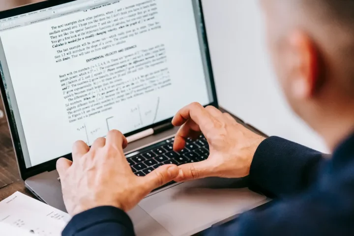 person editing a text document on a laptop